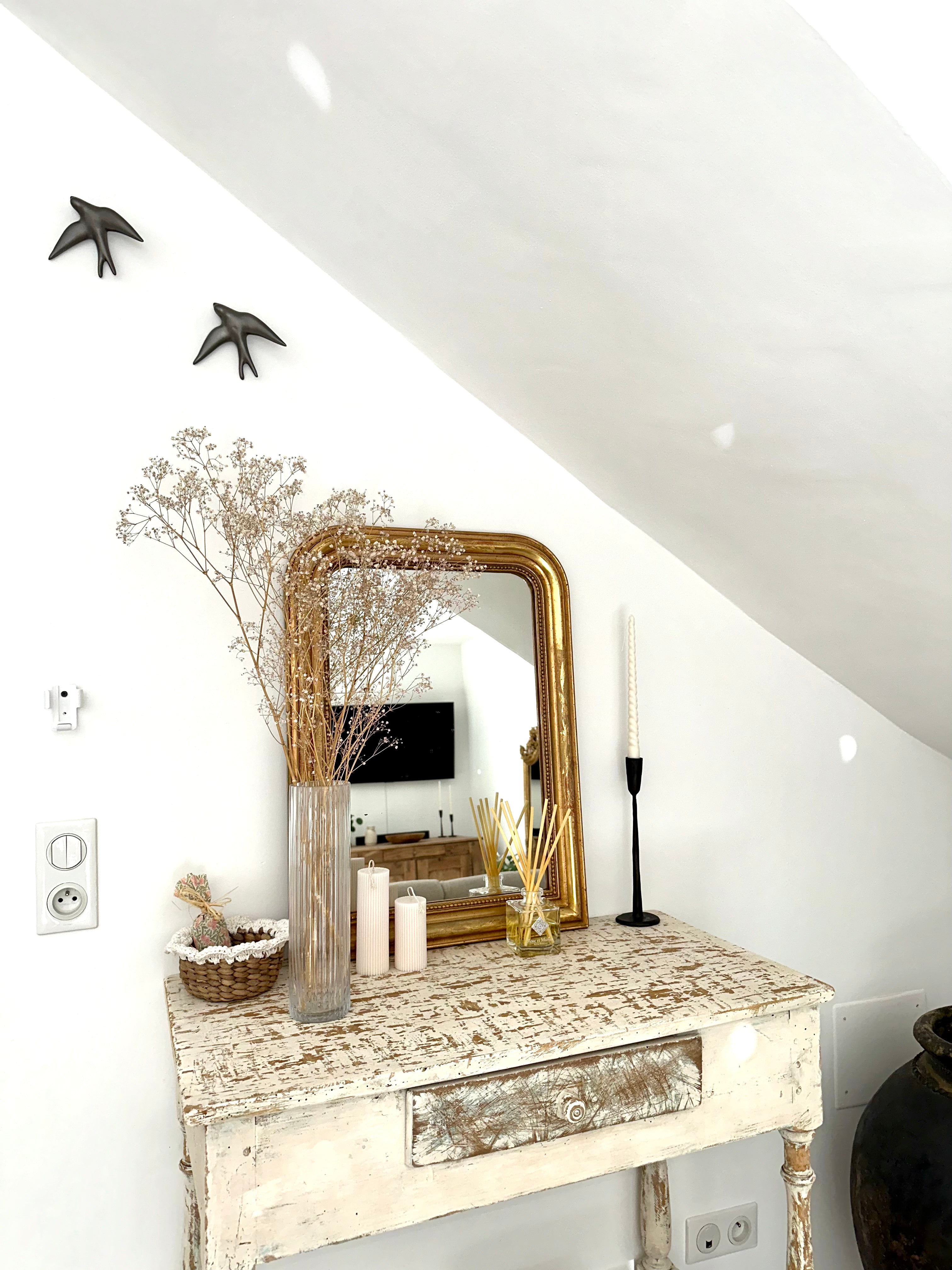 Miroir Louis-Philippe ancien doré posé sur une console à l'entrée